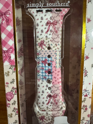 A floral and gingham patchwork-patterned watch band with silver-tone hardware, displayed inside its clear plastic packaging. The packaging features a pink and white floral design with the brand name 'simply southern' printed at the top.